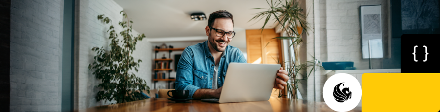 smiling while looking onto the computer screen and reading about Central Florida A Tech Hub That’s Heating Up With Cybersecurity Jobs